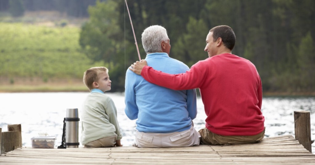Three generations bonding outdoors: a grandfather, father, and son enjoying a shared activity together.